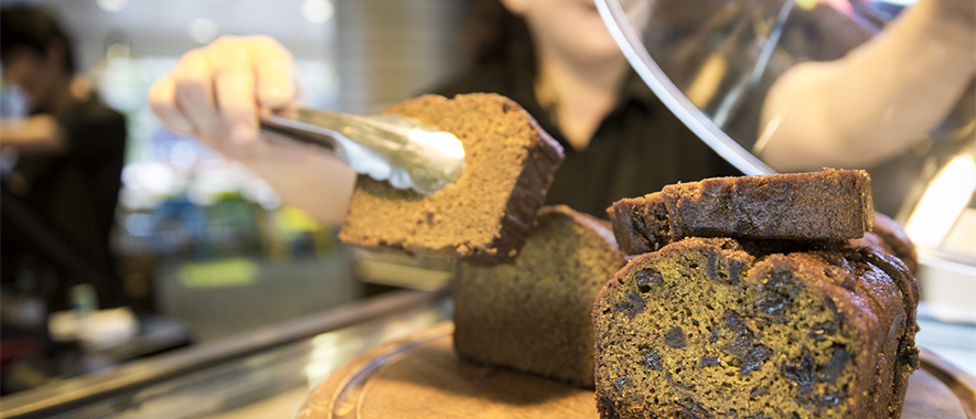 Cafe staff serving a slice of ginger loaf. 