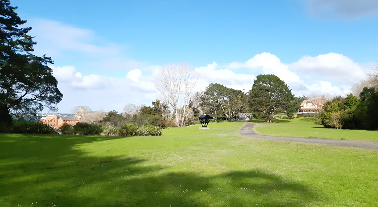 Chelsea Estate Heritage Park - Open grassed space with a path running along the right and lots of established trees.