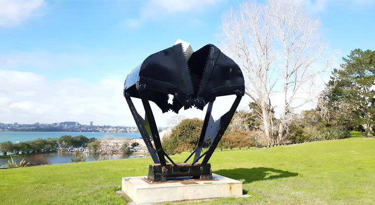 Chelsea Estate Heritage Park - Large black sculpture with the harbour and Auckland city in the background.