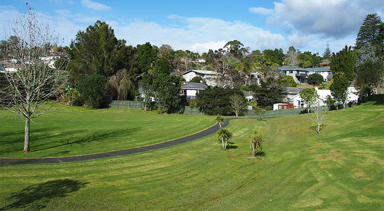 Maire / Emerald Valley Park - Open green space with trees, and a path running through the middle. Photo credit: Tracey Hodder.