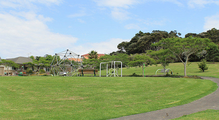 Ferry Road / Hawaiian Parade junction - Open grassed area with the playground and trees in the background. Photo credit: M Loubser.