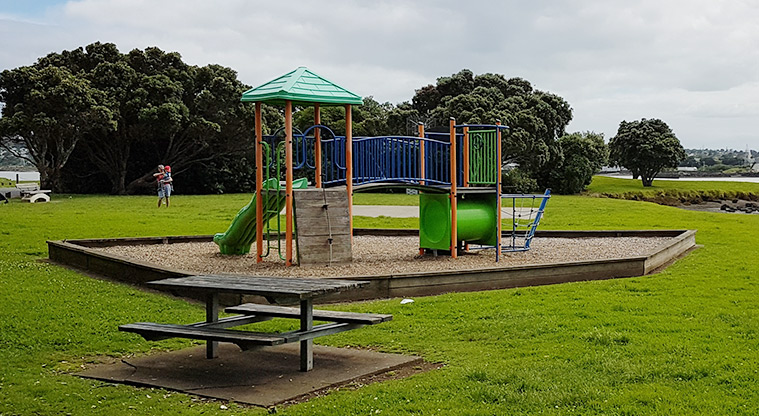 Kiwi Esplanade - Play structure with climbing equipment, bridge, tunnel and slides, and a picnic table in the foreground.