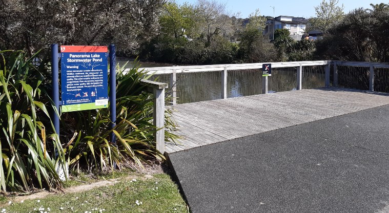 Lake Panorama - Viewing deck with bushes and signboard.
