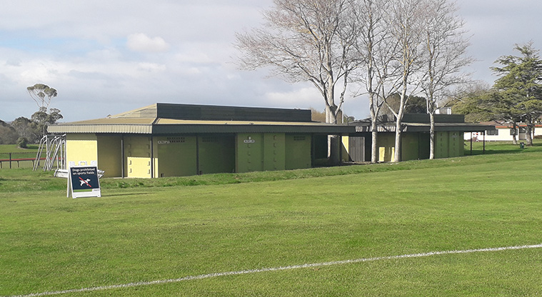 Lloyd Elsmore Park - Section of one of the sports fields with the toilets and changing rooms in the background.