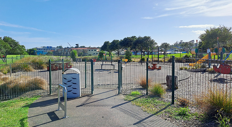 Lloyd Elsmore Park - Fence and rubbish bin with the playground in the background. Photo credit: S Hulse.