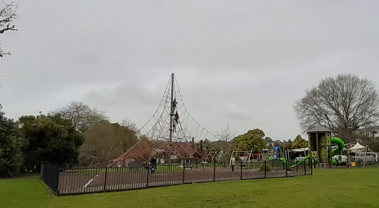 Madills Farm Recreation Reserve - High spider climbing net surrounded by a fence, with the rest of the playground in the background.