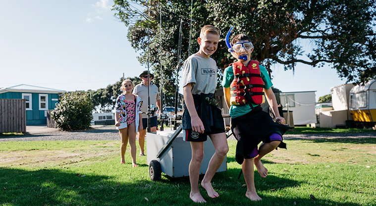 Martins Bay Holiday Park - Two children pulling a trolley with fishing rods, followed by another child and an adult.