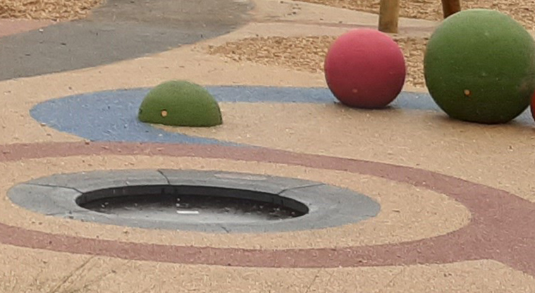 Moire Park - Inground trampoline with large coloured balls in the background.
