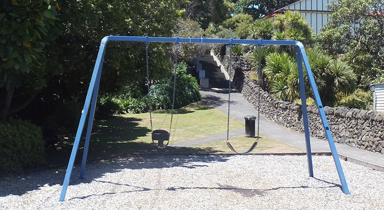 Monkey Hill - Set of two swings with paths, open spaces and trees in the background. Photo credit: J Grigg.