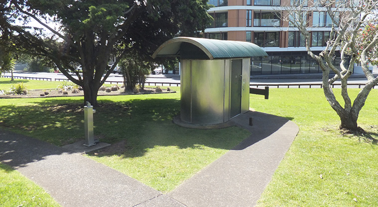 Maungawhau / Mount Eden – Toilets and drinking fountain with open grassed space, trees and buildings in the background. Photo credit: J Grigg.