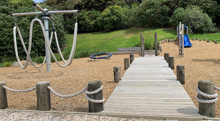 Omana Esplanade - Rope merry-go-round and balance ring with a boardwalk running down the right of them.