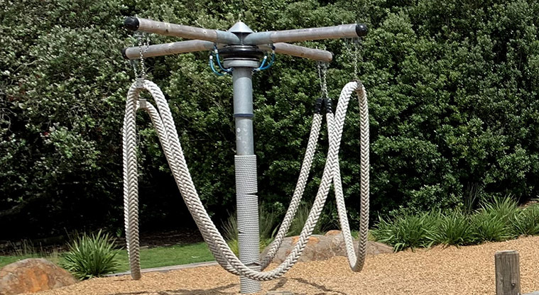 Omana Esplanade - Rope merry-go-round with trees in the background.