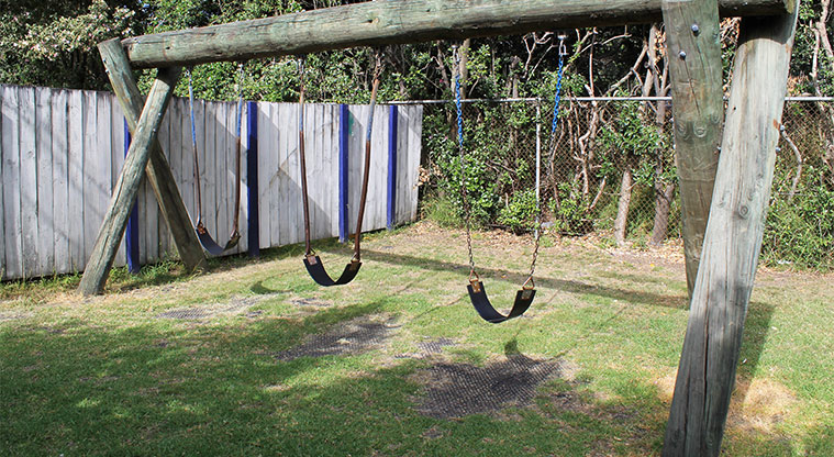 Swing set at Ōrewa Beach Holiday Park.
