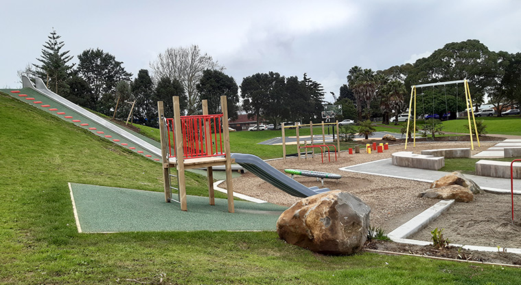 Otamariki Park - Slides with a large boulder in the foreground, and the rest of the playground in the background.