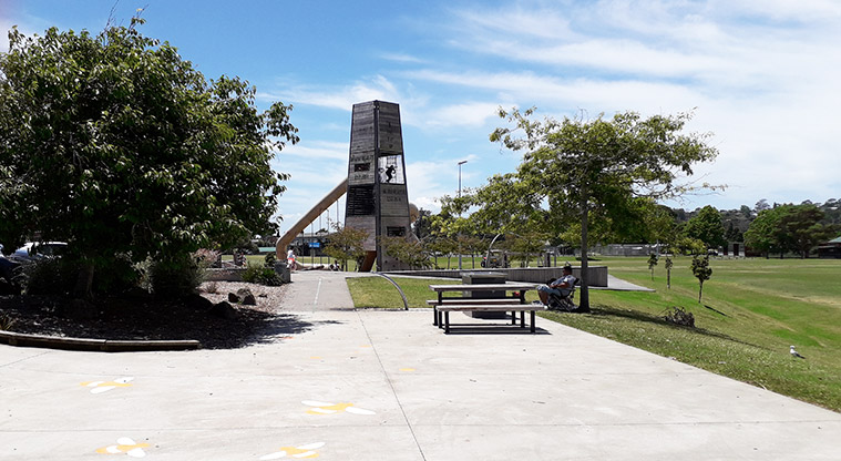 Parrs Park - Large open concreted area with table, seating and the playground in the background.