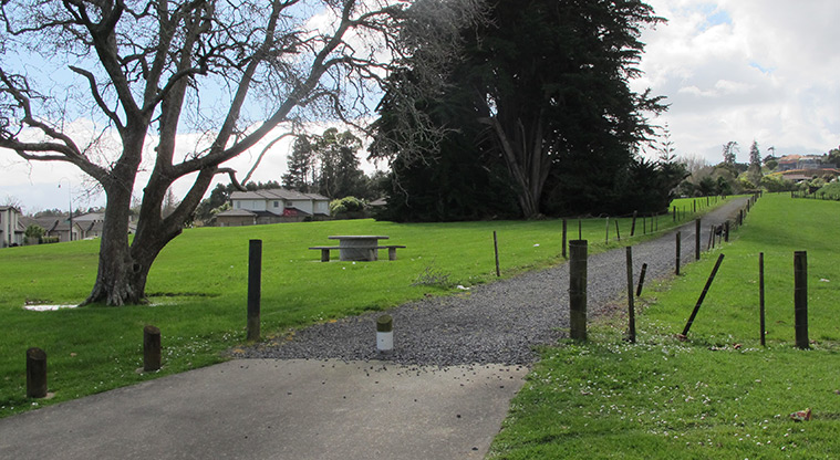 Point View Reserve - Section of gravel path with fences on both sides, open grassed space and trees.