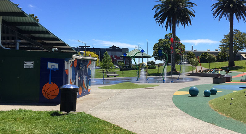 Potters Park – Toilets and playground with large phoenix palms in the background.