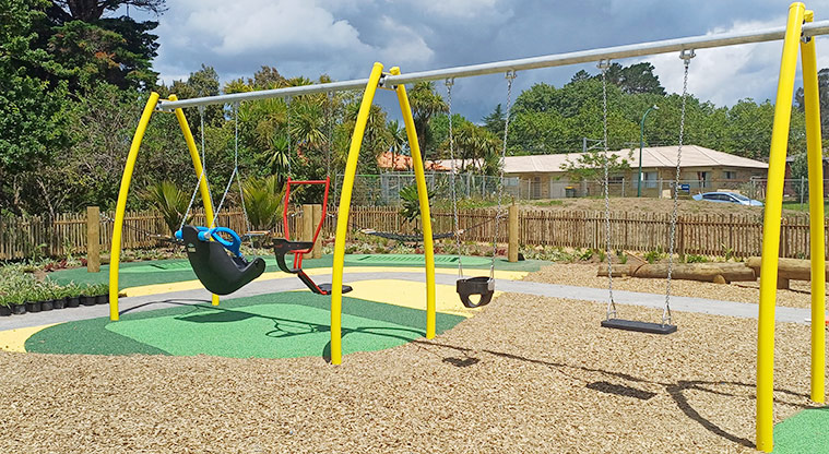 Rānui Domain - Section of the swing set with two inclusive swings, a bucket swing and a flat swings