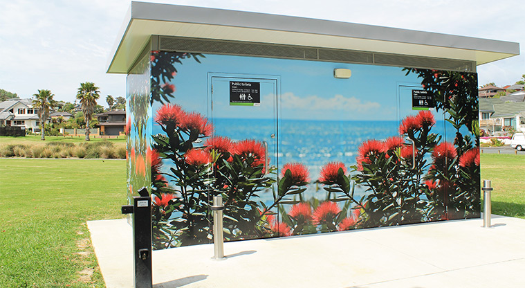 Red Beach Park - Toilets with a pōhutukawa mural, and a drinking fountain in the foreground. Photo credit: M Loubser.