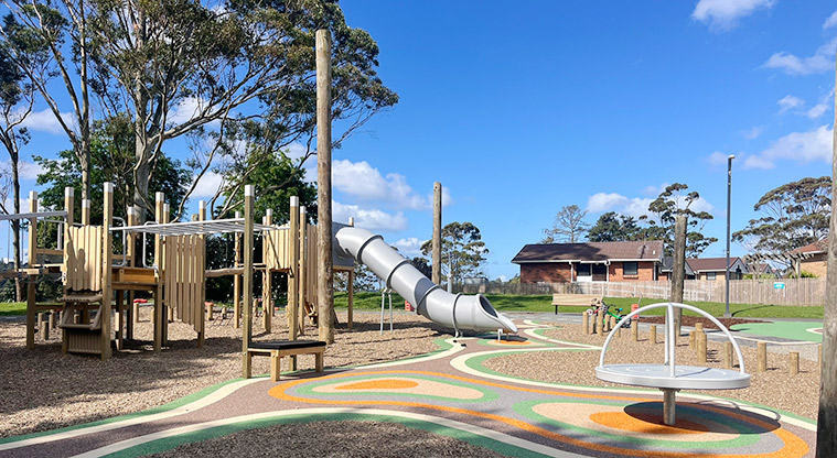 Shepherds Park - Playground with a large play structure, covered slide and spinning carousel..