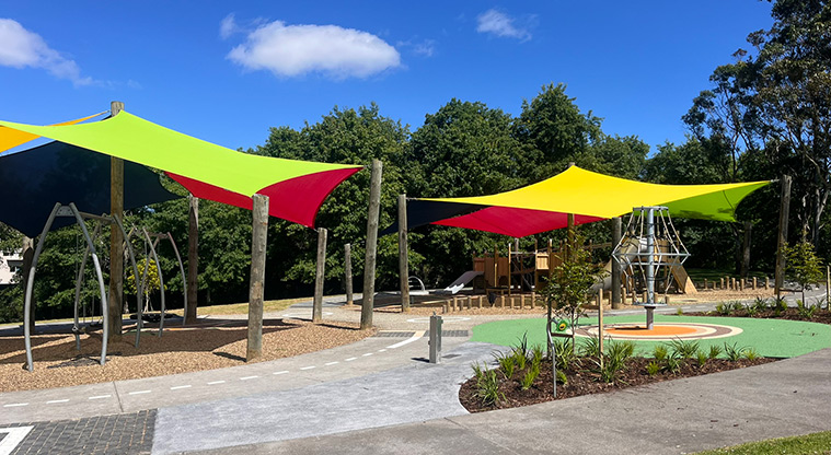 Shepherds Park - Section of garden with the playground under brightly coloured shade sails in the background.