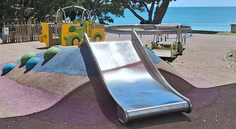 Takapuna Beach Reserve - Low climbing mound with a wide slide, with the rocking truck and seesaw in the background.