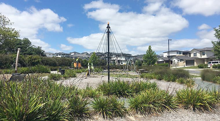 Timberlands Reserve - Section of the playground with a spiders web climbing frame surrounded by gardens.