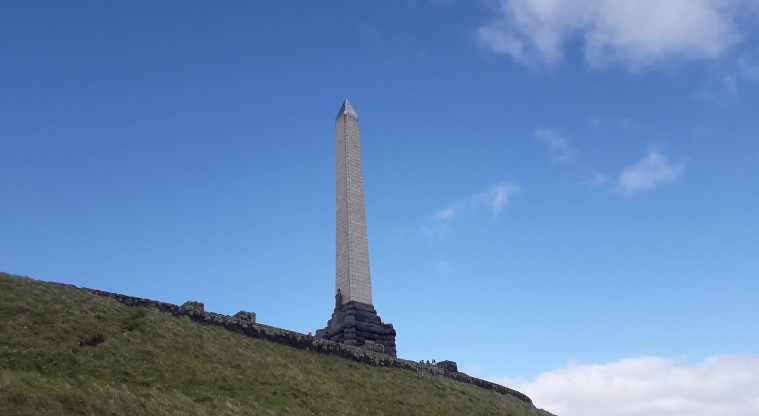 Maungakiekie / One Tree Hill Path - Stone obelisk with a statue of a Māori warrior standing before it.