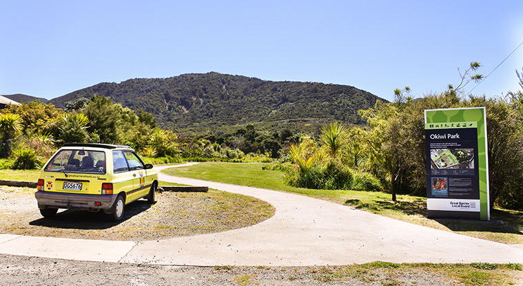 Okiwi Park Path - Main entrance to Okiwi Park, marked by a large parks sign with map.