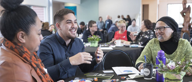 Three people sitting around a table at an event. 